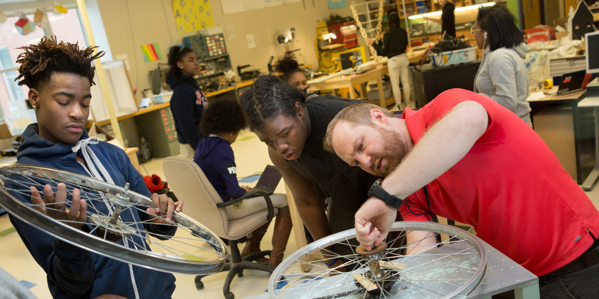 Image of adult and students working on hands-on project