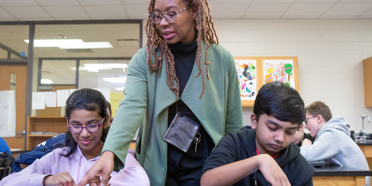 Woman helping two students