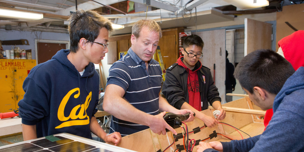 Man helping students with a hands on project